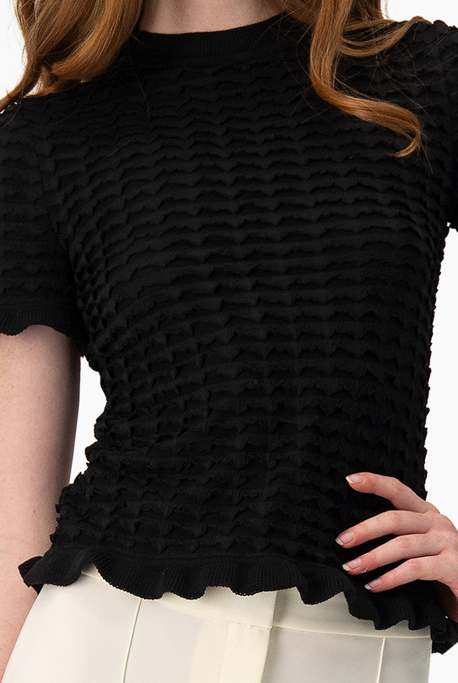 Blusa tejida negra con olanes y textura acanalada